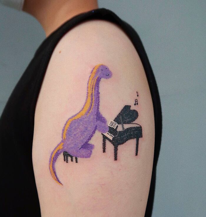 Tatouage d’un dinosaure jouant du piano