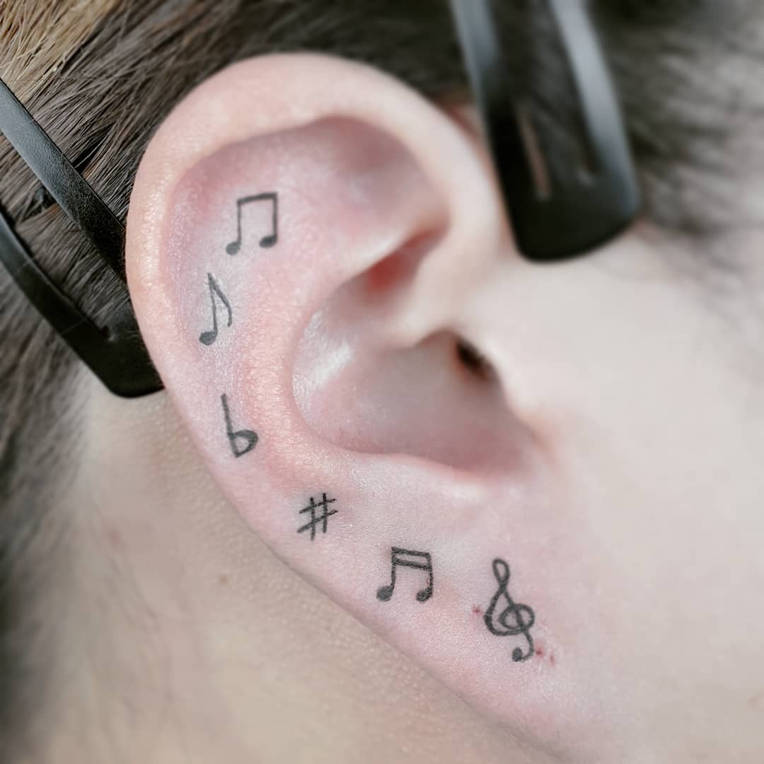 Tatouage de notes de musique sur l’oreille