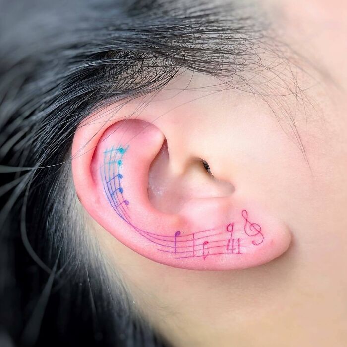 Notes de musique colorées sur le tatouage de l’oreille