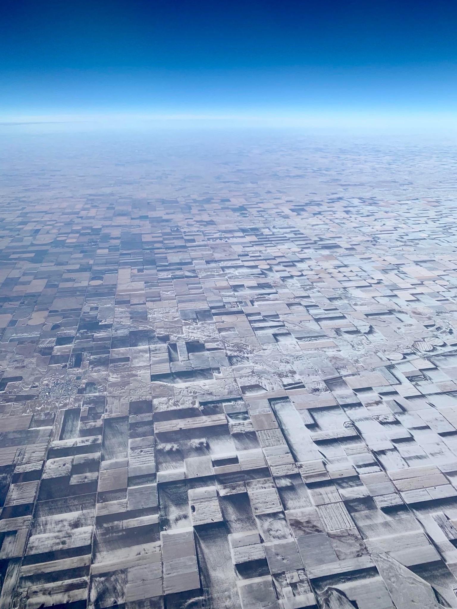 Ces terres agricoles du Colorado sont plates mais ont l’air d’être en 3D après que la neige a été soufflée autour d’elles.