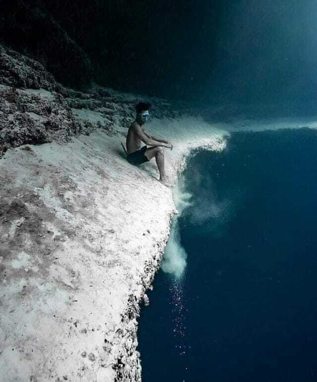 Plongeur assis au bord d’une falaise sous-marine