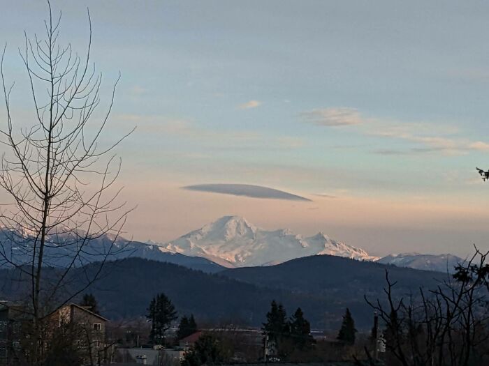 Un nuage lenticulaire au-dessus du mont Baker. Vue du côté nord du mont Baker depuis la vallée du Fraser, en Colombie-Britannique, avec un nuage lenticulaire suspendu au sommet de ce magnifique volcan actif dont le sommet est recouvert de glace et de neige.