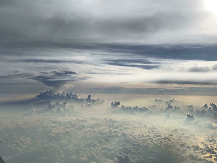 Les nuages à l’extérieur du hublot de mon avion ressemblent à un paysage extraterrestre