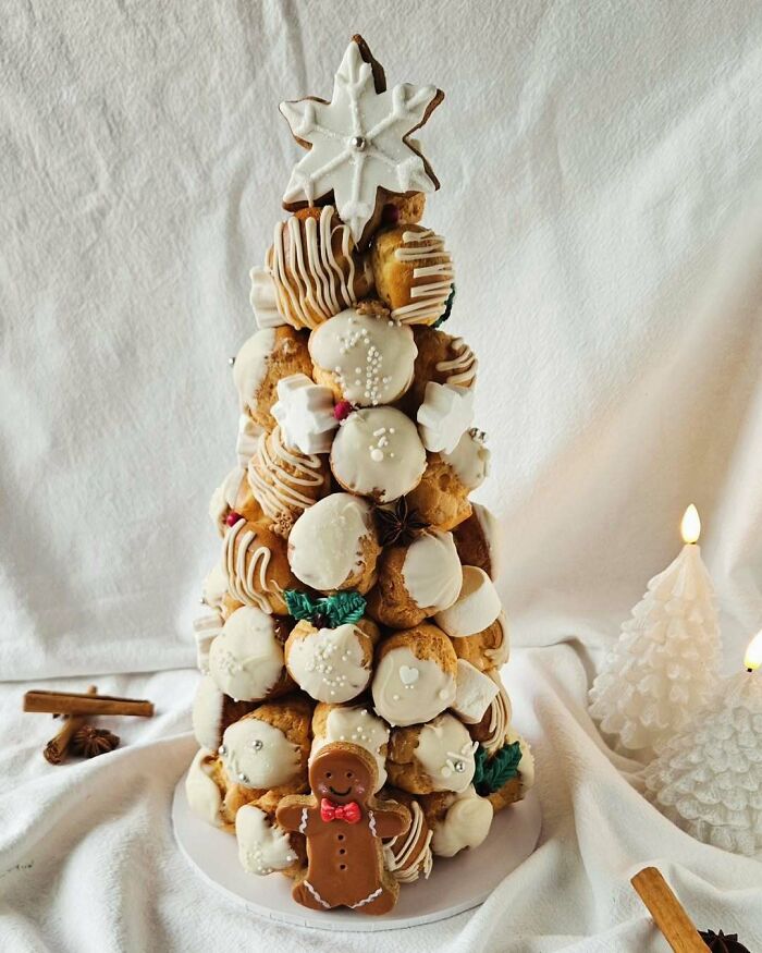 Croquembouche de Noël. Une tour luxueuse de 40-45 Profiteroles remplies d’une riche crème au Brandy et enrobées d’un onctueux chocolat blanc.